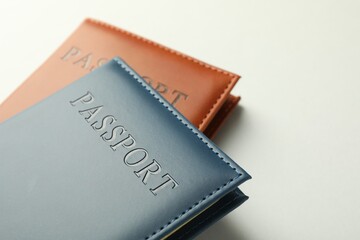 Passports in color covers on light background, closeup