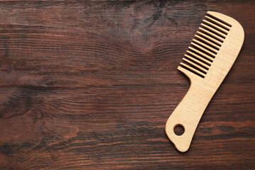 One hair comb on wooden background, top view. Space for text