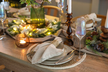 Christmas place setting with festive decor on wooden table in room