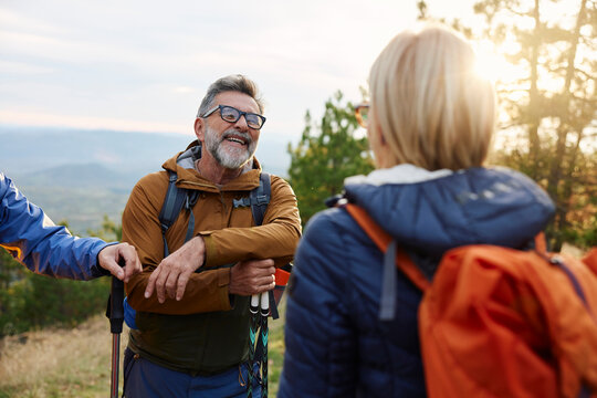 Friends conversing on a mountain at sunset