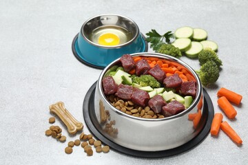 Dry pet food and natural products on light table, closeup