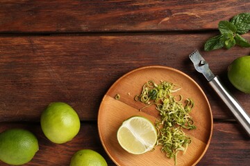 Lime zest, zester, mint leaves and fresh fruits on wooden table, flat lay. Space for text