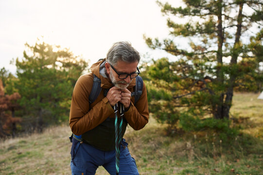 Man takes a moment to rest on a mountain hike