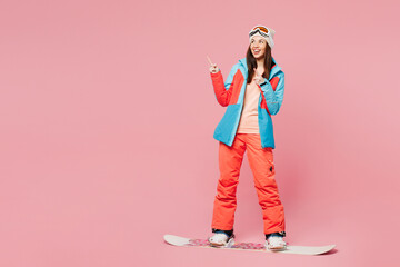 Full body young woman wear blue jacket ski goggles mask spend weekend winter season in mountains...