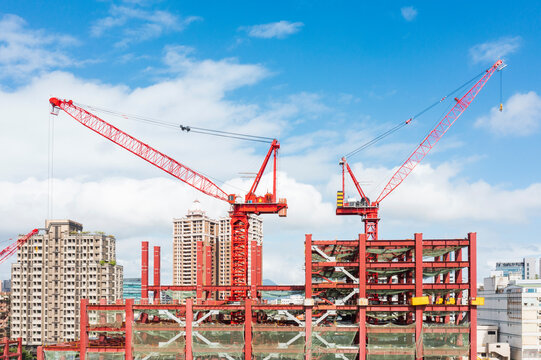 Red Cranes at Construction Site Under Blue Sky