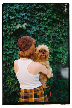 Girl posing with her dog on green leaf background