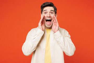 Young happy man he wear white shirt yellow t-shirt casual clothes scream sharing hot news about sales discount with hands near mouth isolated on plain red orange background studio. Lifestyle concept.