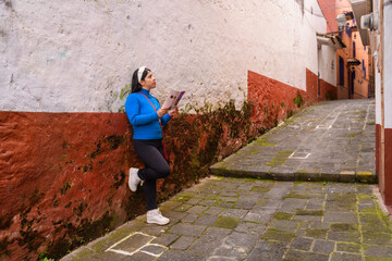 Woman tourist in a Mexican village reading a brochure
