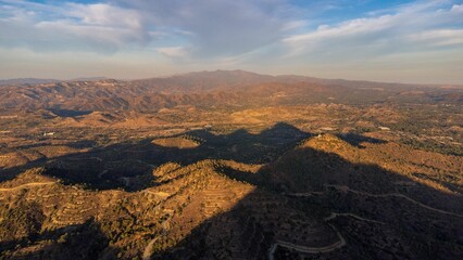 Aerial view of a mountainous landscape with cloud shadows.