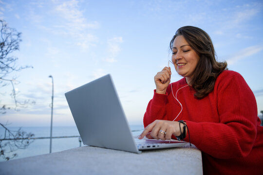 Smiling woman talking on the laptop 