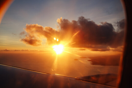 Scenic sunset view from aircraft window over ocean and coastline