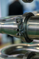 Close-up view of parts and pipes of milk ultra-pasteurization (or ultra-high temperature processing) machine. Industrial background. Soft focus. Copy space. Food and drink processing equipment theme.	