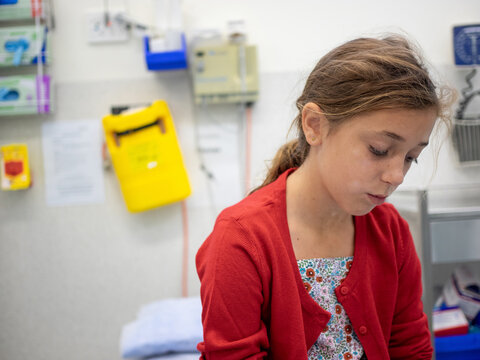 A young girl waits in the emergency department