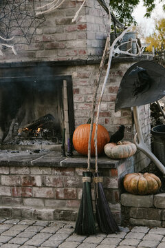 witch's brooms left near outdoor fireplace 