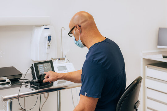 Dentist Adjusting Equipment in a Modern Dental Clinic Setting