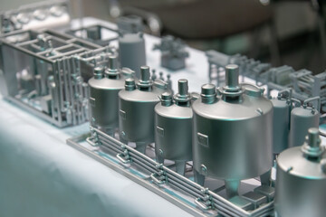 Scale model showcases various industrial tanks and machinery in a well-lit exhibition hall. This intricate display highlights engineering design and innovation.