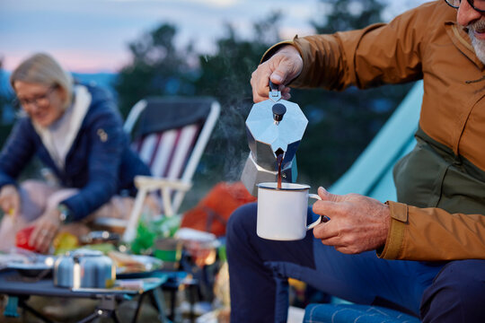 Man serves coffee at the campsite