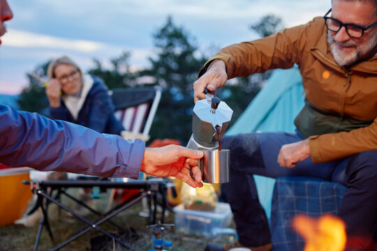 Man serves coffee at the campsite