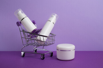 Cream container in mini baskets. White plastic bottles without brand. Bottle with dispenser for cosmetics. Skin care and beauty concept. Mockup style, copy space