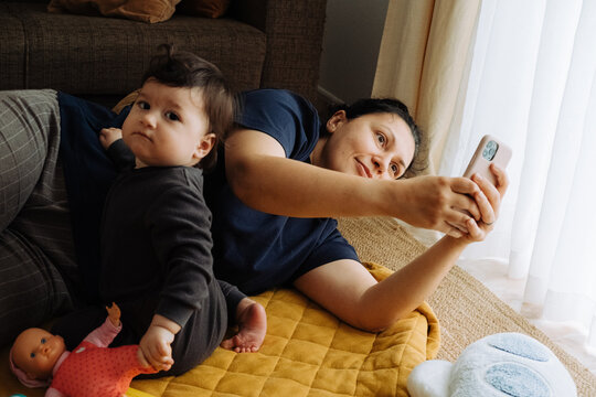 Mother and child on the floor of living room using a mobile phon