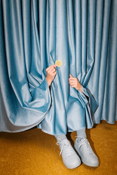 Creative Conceptual Image of Feet Hidden Behind Blue Curtains