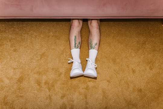 Quirky Tattooed Legs Sticking Out from Sofa