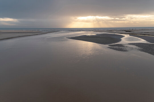 Sunset light on tidal river and beach