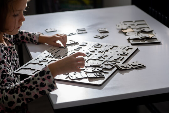 Little child touches with fingers alphabet letters in Braille