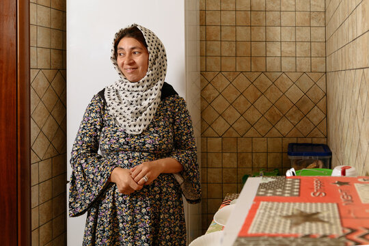 Smiling afghan woman with headscarf at the kitchen