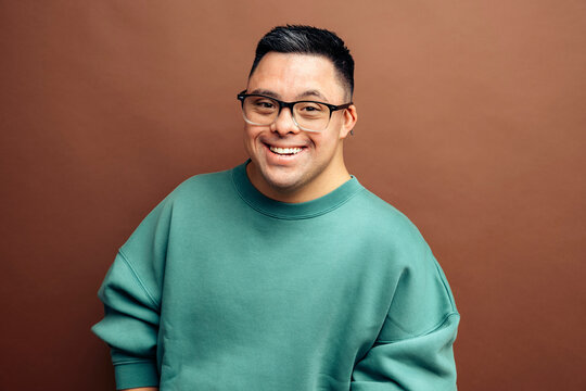 Smiling man with Down syndrome wearing green sweatshirt