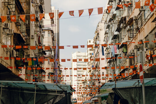 Colorful flags adorn narrow streets in a neighborhood market 
