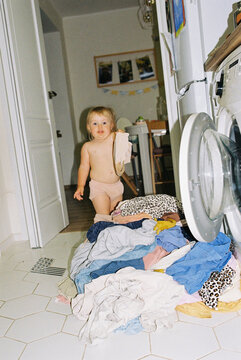 Baby girl takes her wet reusable diaper to the wash.