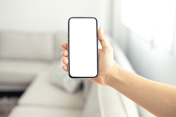 Close up woman hand holding a smartphone blank white screen at home