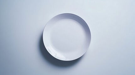 A White Ceramic Plate with a Subtle Rim on a Light Blue Background
