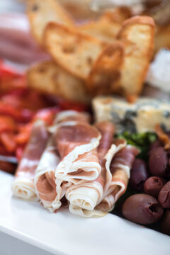 A vibrant gourmet platter featuring cured meats, olives, cheese