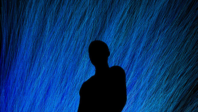 Silhouette of a man against a vibrant technological backdrop