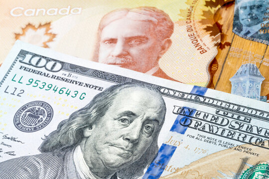 100 US dollar and 100 canadian dollar banknotes. International trade concept