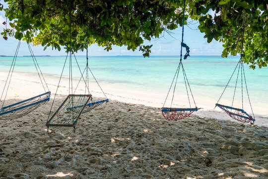 Shaded Swings by a Tropical Shoreline