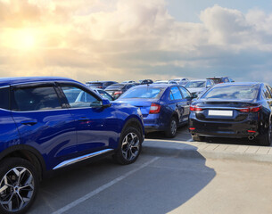 Fototapeta premium cars in a parking lot under a blue cloudy sky