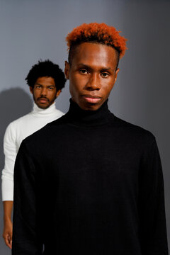 Two men in contrasting turtlenecks