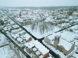 Fototapeta premium Aerial drone view of small town during a snow storm. Cinematic look. 