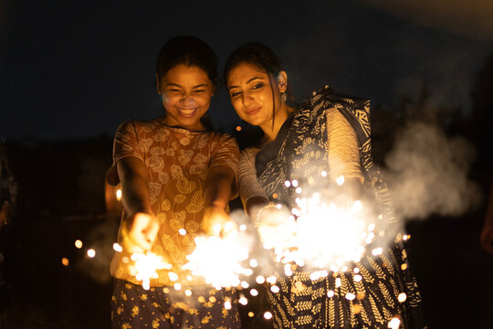Indian women celebrating Diwali and happy new year by burning sparkler