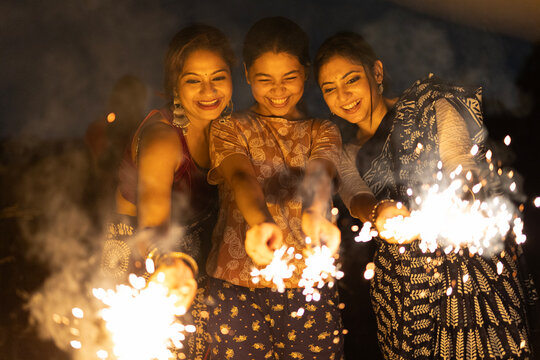 Indian women celebrating Diwali and happy new year by burning sparkler