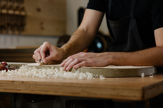 Young luthier crafting traditional Spanish flamenco guitar