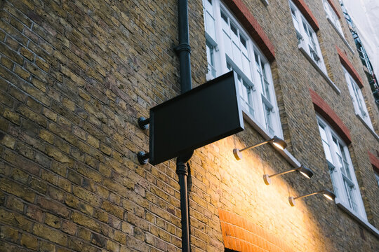Lit Sign on Brick Wall