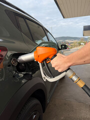 Fototapeta premium A person is filling up a car with gas