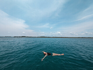 Woman enjoying just floating in the sea off the coast of Sri Lanka