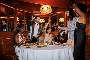 Elegant friends raising glasses at New Year's eve ugc