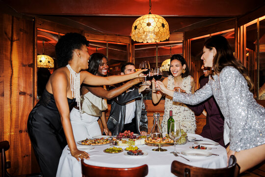 Elegant friends toasting glasses at party dinner ugc