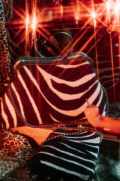 Stylish zebra print handbag displayed with vibrant lighting effects.